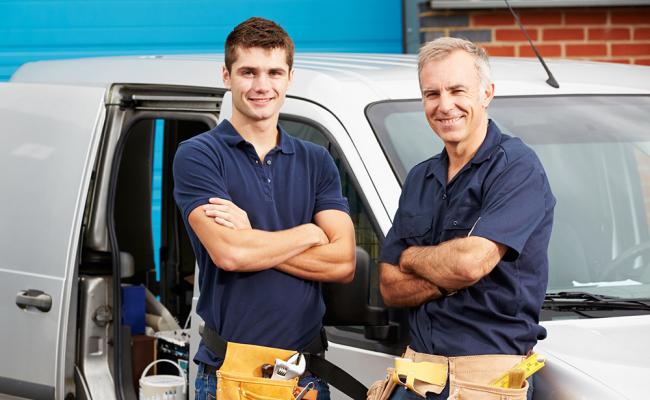 Plumbers standing in front of white van